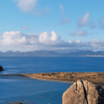 מטייל עומד מעל חוף פראי במסלול ראקיורה טרק ומביט אל האוקיינוס והאיים הרחוקים